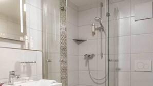 A bathroom with a shower, toilet, and sink.
