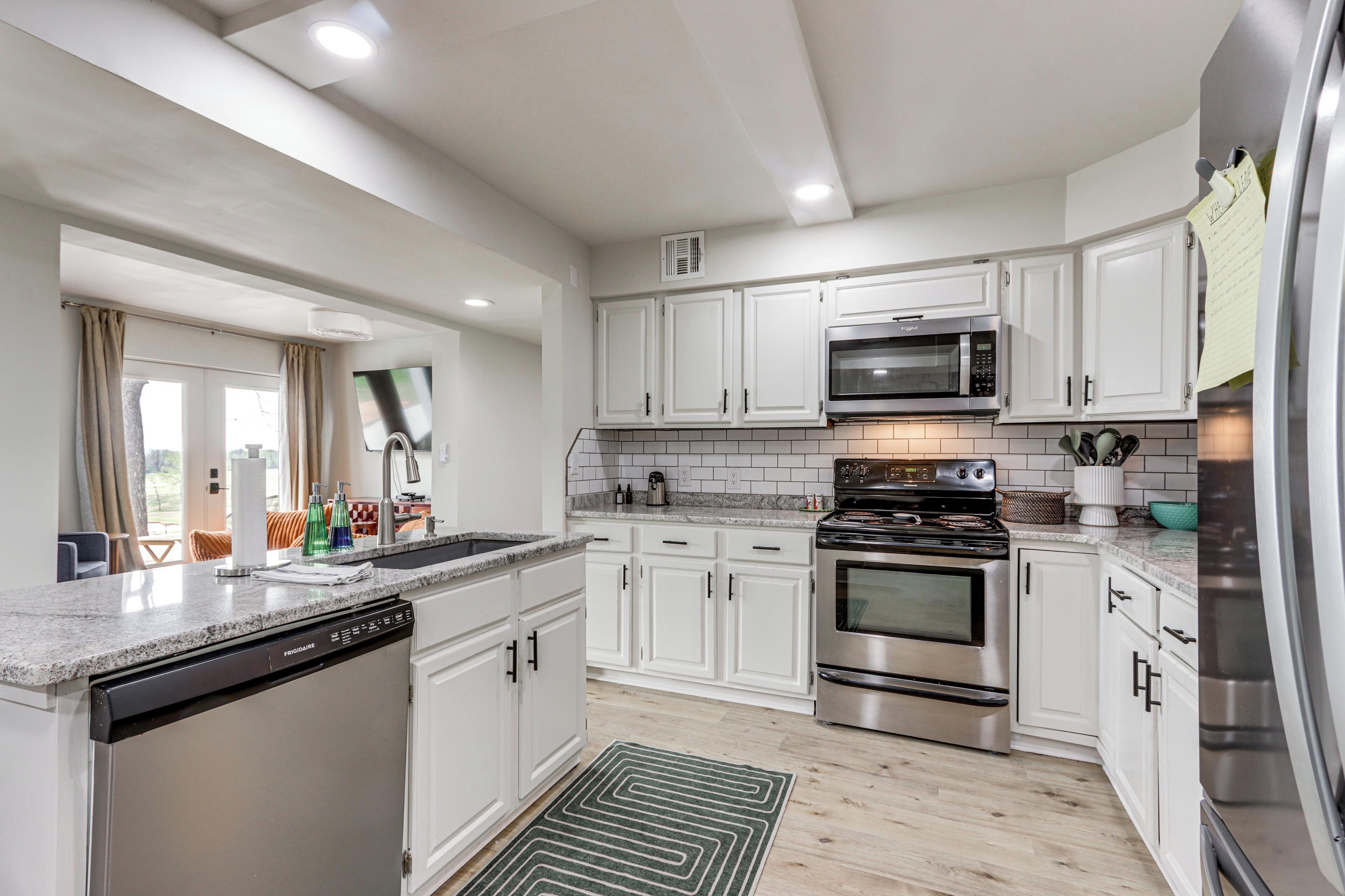 A modern kitchen with white cabinets, stainless steel appliances, and a dishwasher.