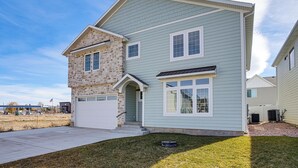 A two-story house with a stone facade, a garage, and a well-maintained lawn. - 'bearly Behaven' Near Bear Lake & Marina! (Garden City)