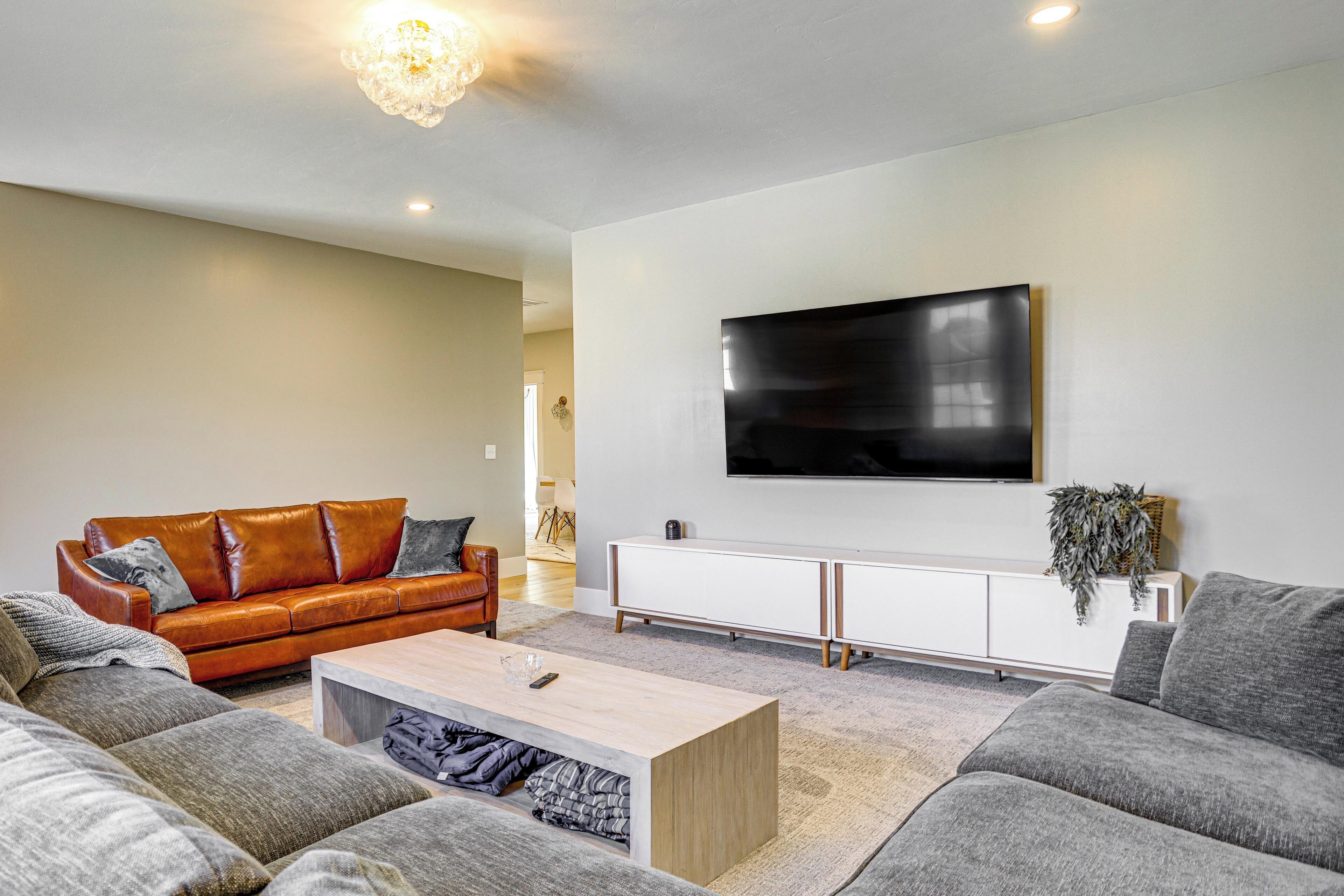 A modern living room with a sofa, coffee table, and a TV mounted on the wall.