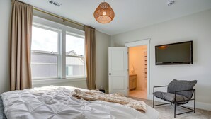 A bedroom with a bed, a chair, a TV, and a window with curtains. - 'bearly Behaven' Near Bear Lake & Marina! (Garden City)