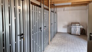 A room with metal lockers, a kitchenette with a stove, and a tiled floor.