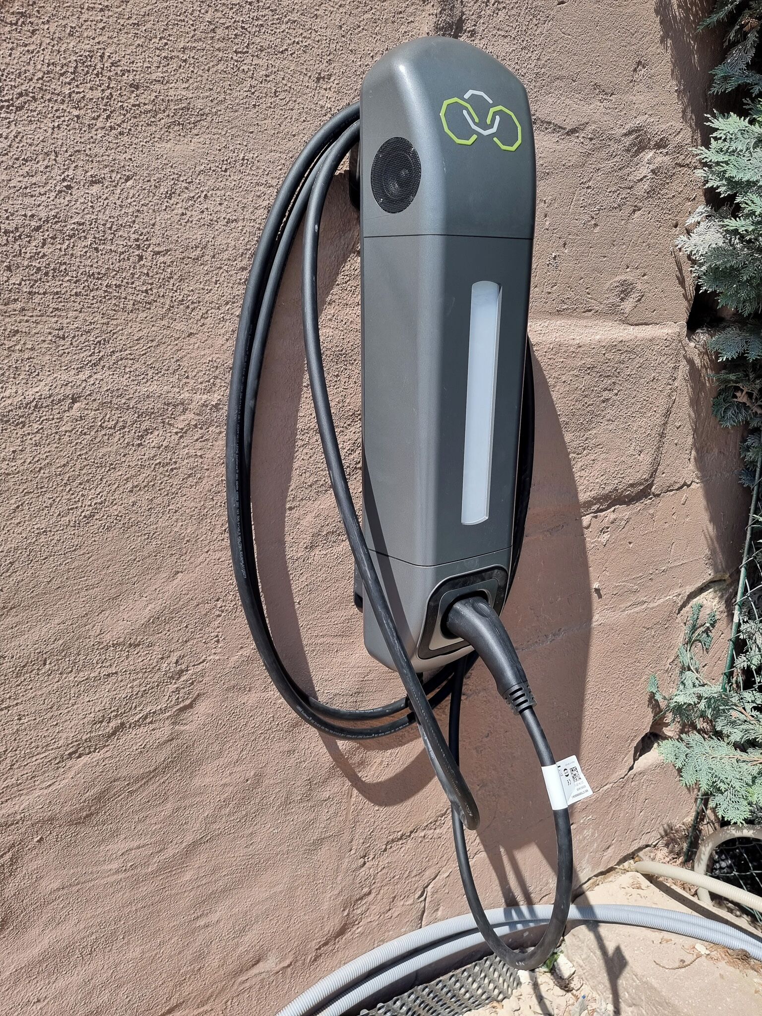 A solar panel charger mounted on a textured wall.
