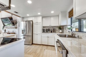 A modern kitchen with white cabinets, stainless steel appliances, and a large island. - Creekside Nature Retreat Near Yosemite Natl Park! (Oakhurst)