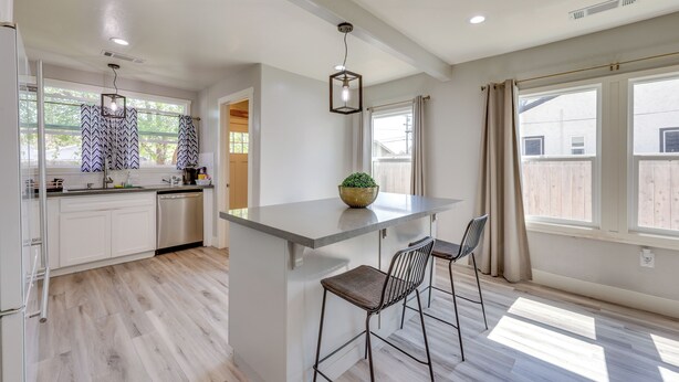 A modern kitchen with a central island, bar stools, and pendant lighting. - < 1 Mi to Main St Hanford! Home w/ Outdoor Space (Hanford)