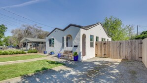 A single-story house with a white exterior, a wooden fence, and a small patio with a bench and potted plants. - < 1 Mi to Main St Hanford! Home w/ Outdoor Space (Hanford)