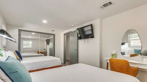 A hotel room with two beds, a desk, a chair, a TV, a mirror, and a window. - Pensacola Retreat: Near Fall Festivals & Events (Gulf Breeze)