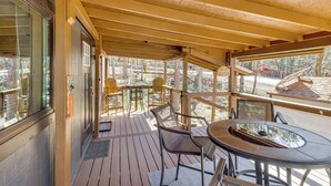 A wooden deck with outdoor seating, a glass door, and a view of the surrounding area. - 1 Mi to Woodland Lake! Cabin w/ Dog-friendly Yard (Pinetop)