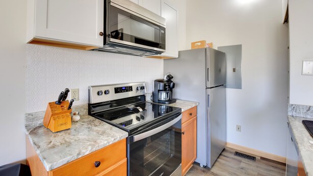 A compact kitchen with a microwave, stove, refrigerator, and a coffee maker on the countertop. - Lake Keowee Gem! Close to Clemson & Hiking Trails (Seneca)