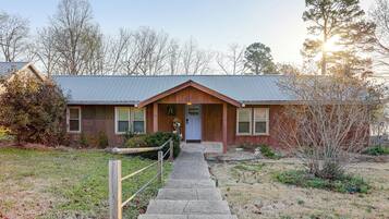 A two-story building with a front porch, a wooden door, and a metal roof.