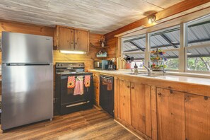 Une cuisine dotée de meubles en bois, d’un réfrigérateur en acier inoxydable, d’une cuisinière, d’un four à micro-ondes et d’un lave-vaisselle.