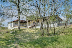 Une maison avec un toit en pente, un balcon et une cour clôturée.