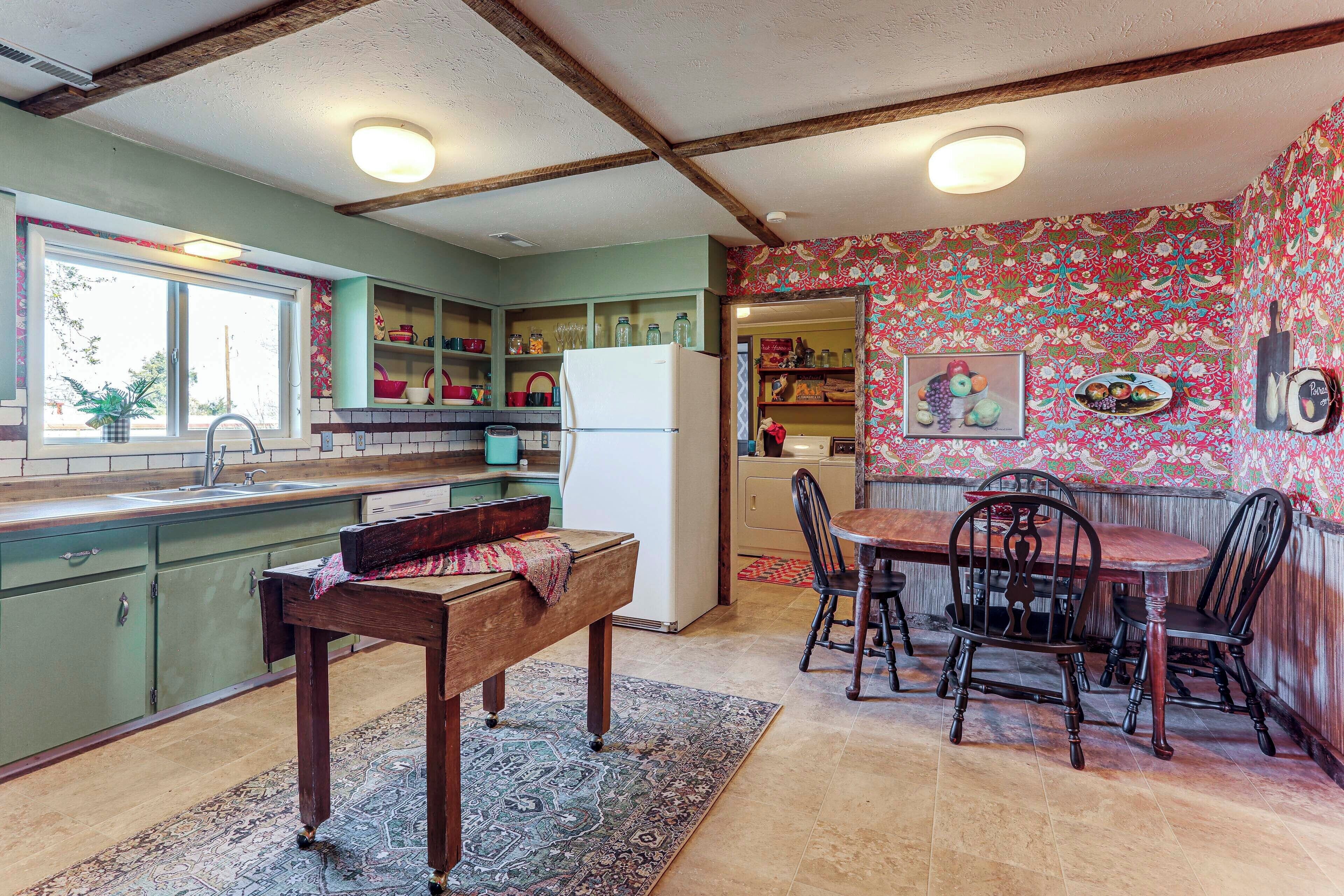 A kitchen with a dining table, chairs, a bench, and a refrigerator.
