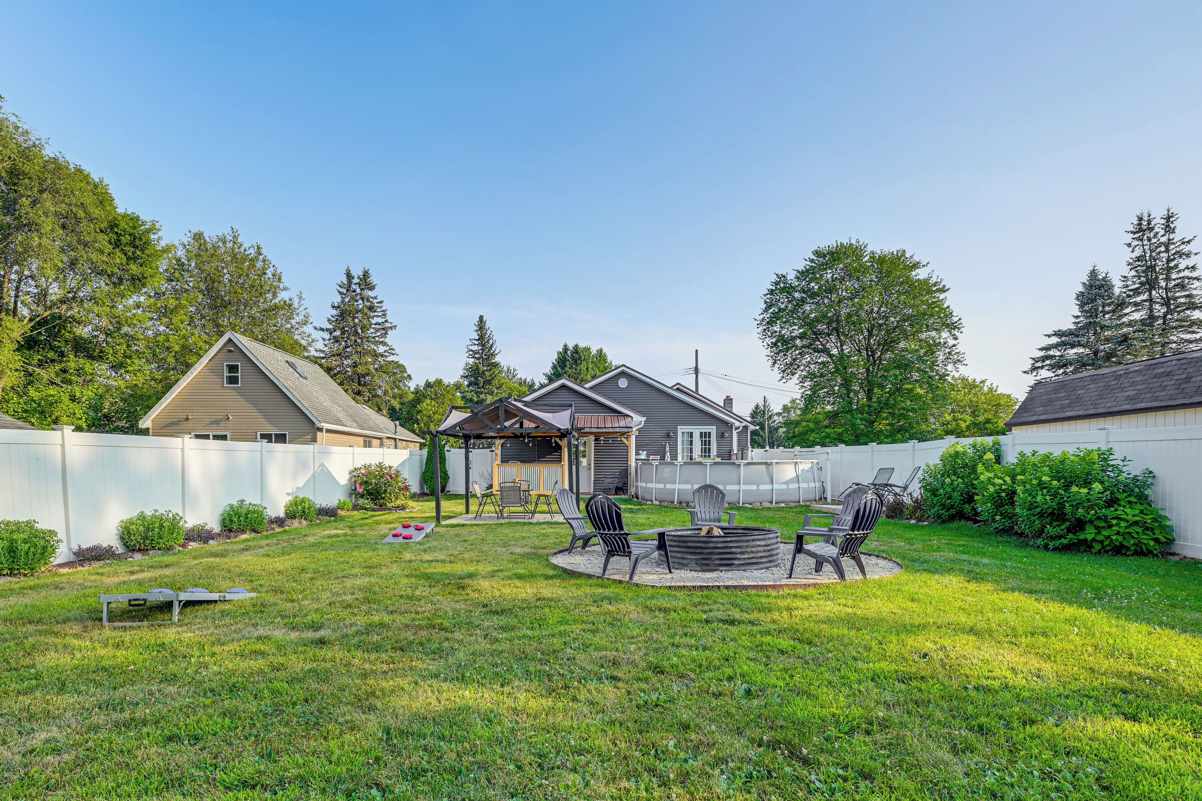 Un jardin avec un espace barbecue, une terrasse couverte et un jardin clos.