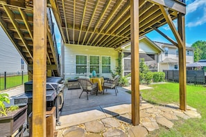 A covered patio area with a grill, outdoor seating, and a stone pathway. - Deck, Patio! Charming Concord Studio Near Speedway (Concord)