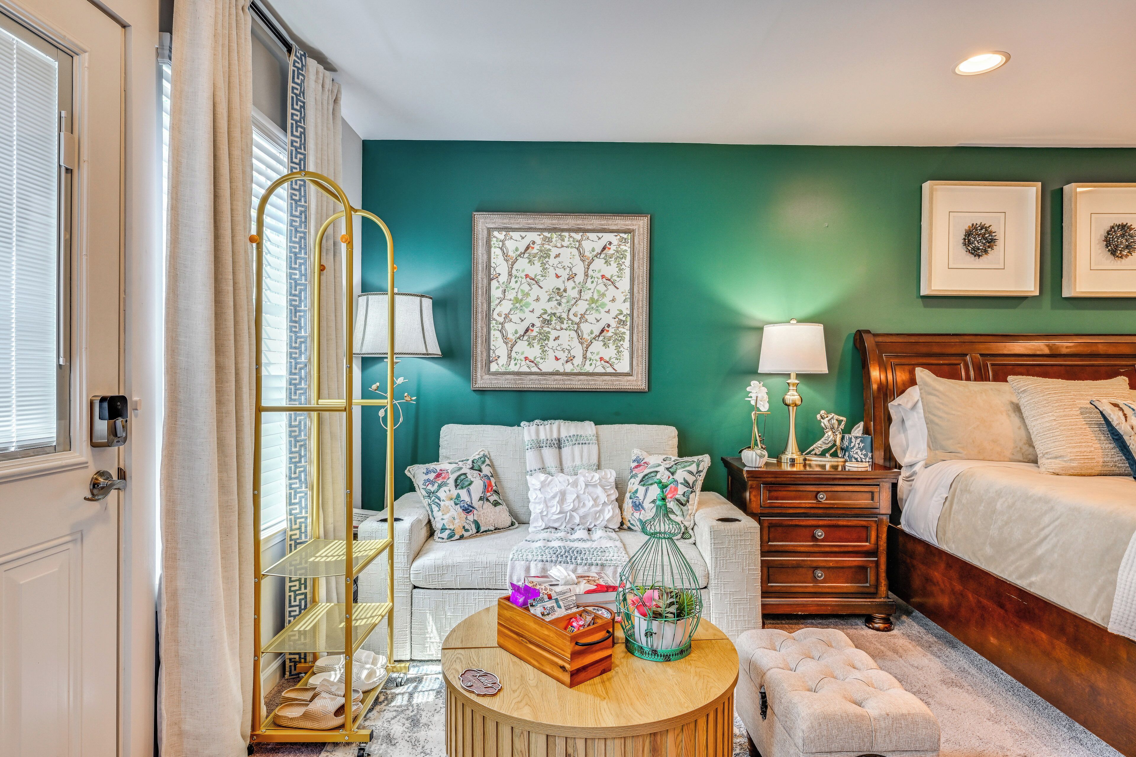 A bedroom with a bed, a nightstand, a dresser, a chair, a lamp, a picture frame, and a window with curtains.