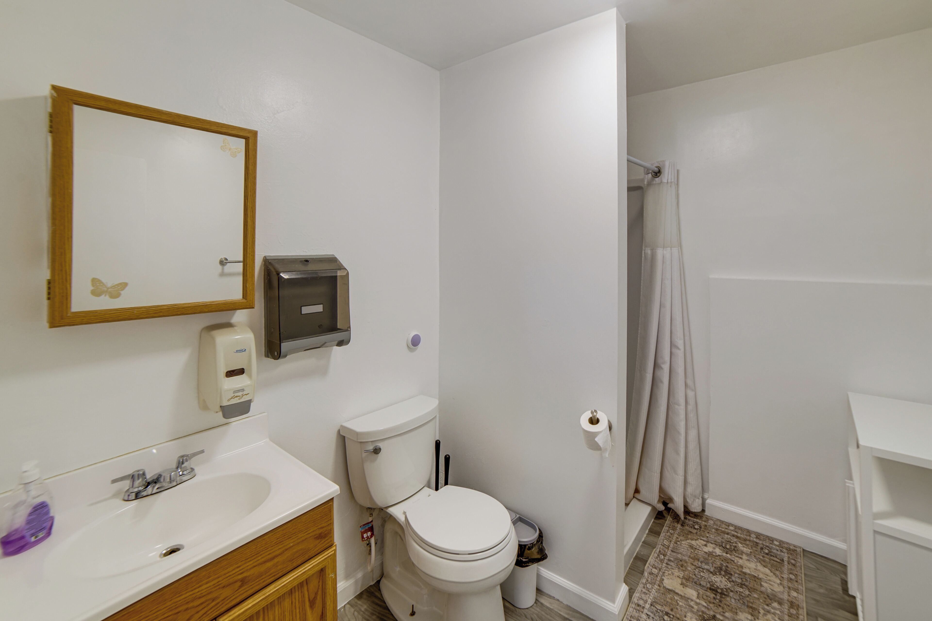A bathroom with a toilet, sink, and shower curtain.
