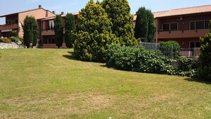 Un quartier résidentiel avec des maisons, une pelouse bien entretenue et un grand arbre.