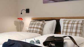 A hotel room with two beds, a nightstand, a lamp, a pair of glasses, and a bag. - Comfortable double room in Heidenheim with WLAN, free parking (Heidenheim)
