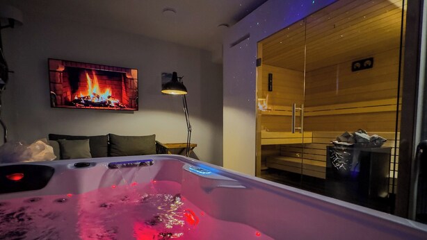 A modern room with a heated tub, a fireplace, and a sauna. - Day SPA Design Muhr - Muhr am See (Muhr am See)