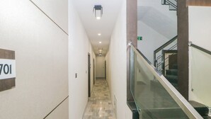 A hallway with a marble floor, a glass railing, and a sign indicating room number 701. - Super Collection O Ranchi Station Road (Ranchi)