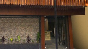 A building entrance with a tiled patio, a brick wall, and a wooden roof. - Super Collection O Ranchi Station Road (Ranchi)