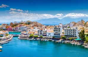 A coastal cityscape with buildings, a marina, and boats. - The Sand Suites Residence (Crete)