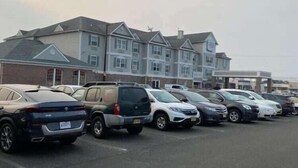 A parking lot with multiple cars and a row of buildings in the background. - Best Western Plus Atlantic City West Extended Stay And Suites (Pleasantville)