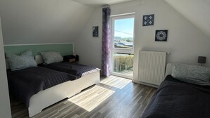 Une chambre avec deux lits, un radiateur et une fenêtre donnant sur un beau paysage.