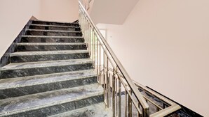 Eine Treppe mit Marmorstufen und einem Metallgeländer, das zu einer Empode führt.