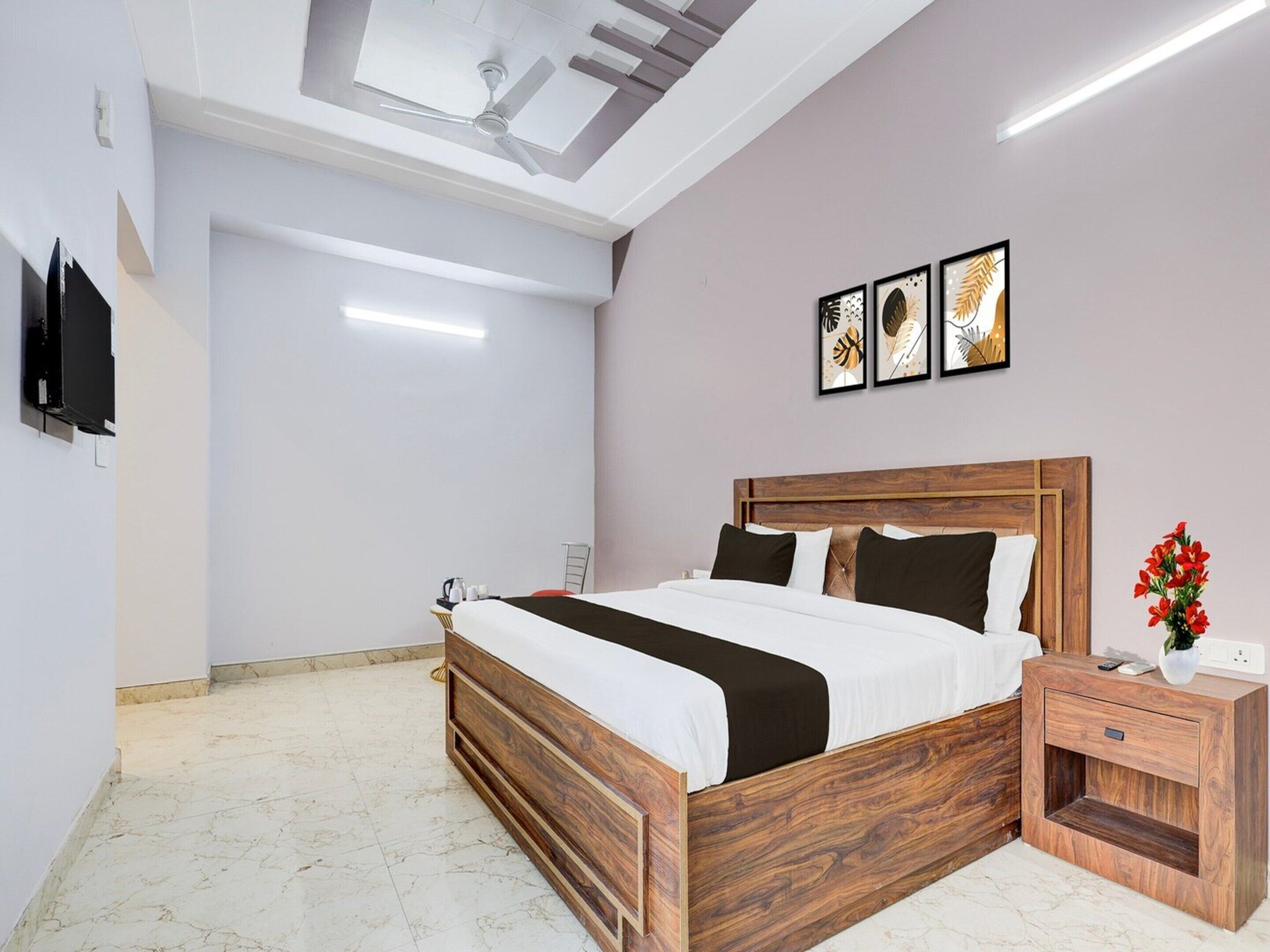 Une chambre à coucher avec un lit en bois, une table de chevet et une œuvre d’art accrochée au mur.