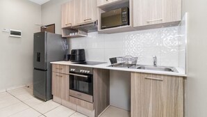 Eine moderne Küche mit Kühlschrank, Backofen, Mikrowelle und Spüle.