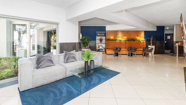 Ein modernes Interieur mit einer Couch, einem Couchtisch und einem Empfangsbereich mit einem Schild.