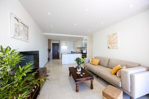 Ein modernes Wohnzimmer mit einer Couch, einem Couchtisch und einem Fernseher.