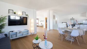 A modern apartment with a living room, dining area, and kitchen.