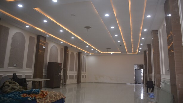 A spacious room with a high ceiling, recessed lighting, and a large mirror. - The Ramayan (Orchha)