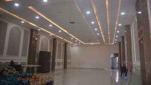 A spacious room with a high ceiling, recessed lighting, and a large mirror. - The Ramayan (Orchha)