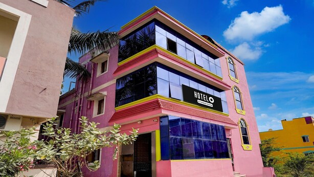 Un hotel rosa y amarillo con un letrero que indica que es un hotel.