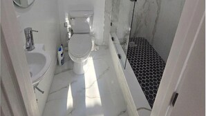 Un baño moderno con inodoro, lavabo y ducha.