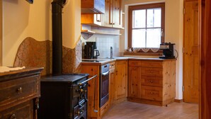 Cocina con armarios de madera, estufa y ventana.