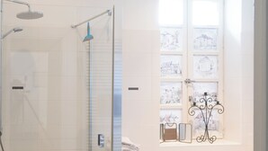 Une salle de bain moderne dotée d’une douche à parois de verre, d’une baignoire et d’une fenêtre ornée de panneaux décoratifs.