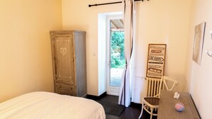 Une chambre à coucher avec un lit, une armoire en bois, un bureau avec une chaise et un panneau motivant accroché au mur.