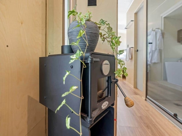 Une cuisine moderne avec un four encastré, un grand vase à rayures et une plante en pot.