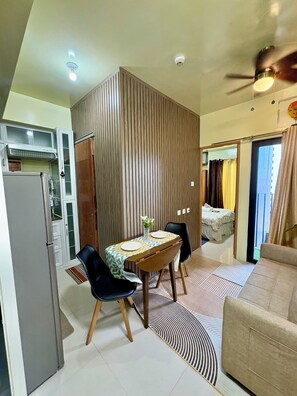 Un espacio habitable pequeño con kitchenette, comedor y sofá.