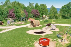 A playground with various play structures, a small pavilion, and a clear view of the surrounding greenery and trees. - Feriendorf an der Ostsee, Wohlenberg (Wohlenberg)