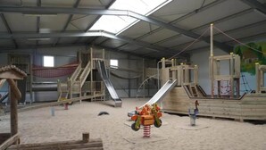 An indoor play area with slides, climbing structures, and a sandbox. - Feriendorf an der Ostsee, Wohlenberg (Wohlenberg)
