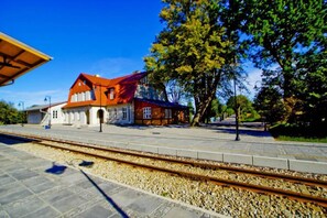 A train station with a red-roofed building, tracks, and a platform. - Comfortable holiday home (No. 2), summer pool (Rewal)