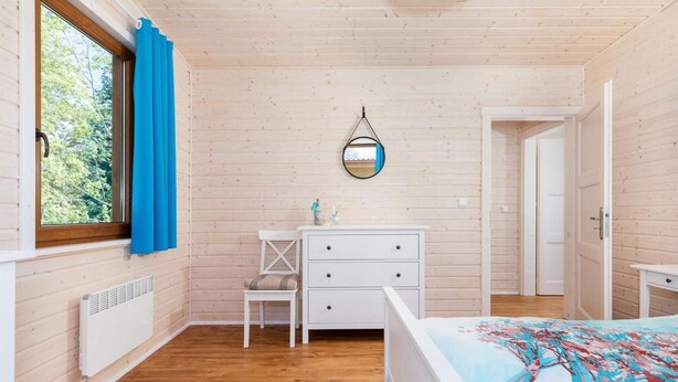 A bedroom with a bed, a dresser, a chair, a mirror, and a window with curtains. - Comfortable holiday home (no. 6), summer pool (Rewal)