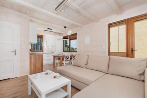 Ein modernes Interieur mit einer Couch, einem Esstisch und einer Küchenzeile.