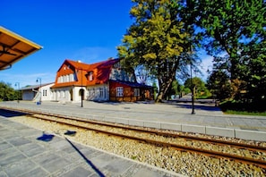 A train station with a red-roofed building, tracks, and a platform. - Comfortable holiday home (no. 10), summer pool (Rewal)